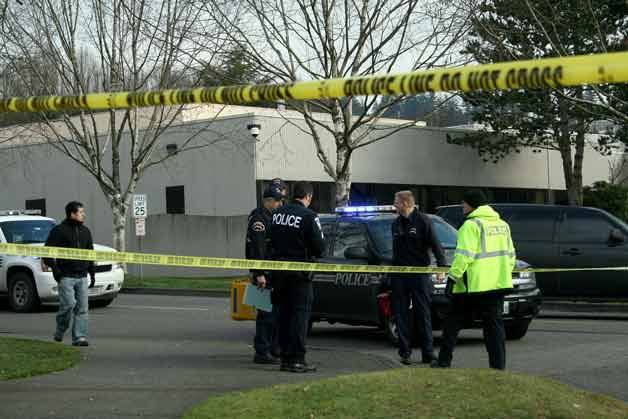 Bothell police gather outside of the regional Food and Drug Administration building in Bothell where police say an FDA security guard fired gun shots at a 15-year-old driver outside the building early Friday morning.