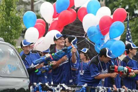 North Bothell Little Leaguers spray the crowd with waterguns during last year’s Fourth of July Grand Parade.