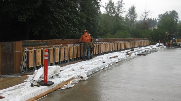 Construction crews prepare for the pouring of concrete for the rails on the new Swamp Creek Bridge in Bothell.