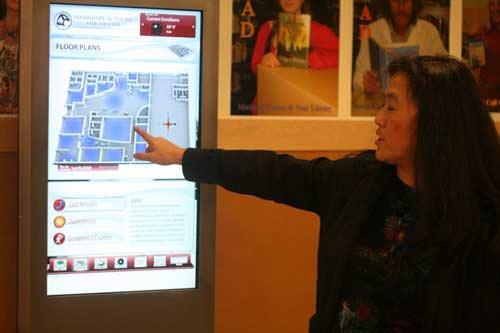 SAS Principal Vicki Puckett points to an interactive education kiosk