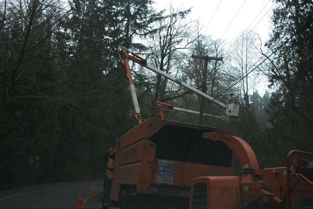 Crews fix a broken power line at a street near Juanita Dr. N.E.