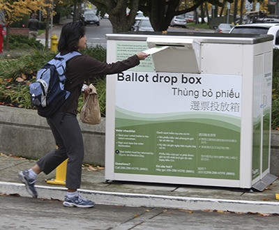 A King County resident drops off her ballot in the Redmond drop box on Tuesday.