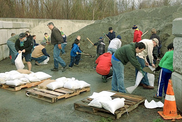 Cub Scouts and their parents from Pack 584 of Bothell fill sandbags at the Bothell Operations Center to replenish the city’s supply.