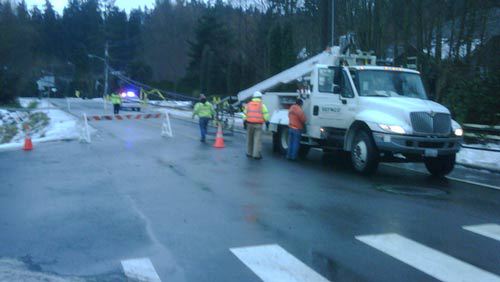 Police and Sefnco Communications workers survey the scene on East Riverside Drive in Bothell.