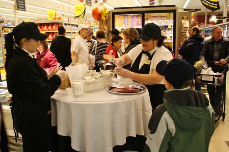 Employees hand out free samples this morning at the grand opening of the new 50