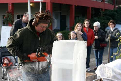 Artist David Westberg attracts a crowd as he begins to cut away on a block of ice during the “Taste of the Holidays” event Nov. 20 at Bothell’s County Village. Westberg usually works with wood. It took only a few minutes before  his icy nutcracker began to take shape.