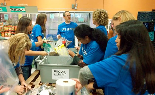 AT&T employees bag cat food for the food bank. From left