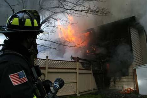 A Northshore department firefighter prepares to help extinguish a Lake Forest Park house blaze.