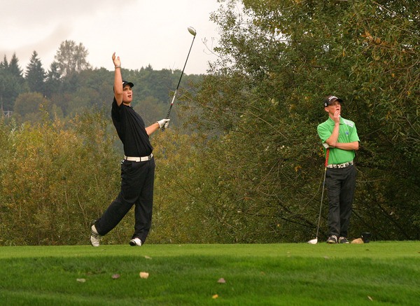 Inglemoor's Cole Hublou waves and yells 'fore' after pushing his drive to the right on the 15th hole during the final round of the 4A Kingco District Tournament at Willows Run Golf Club in Redmond