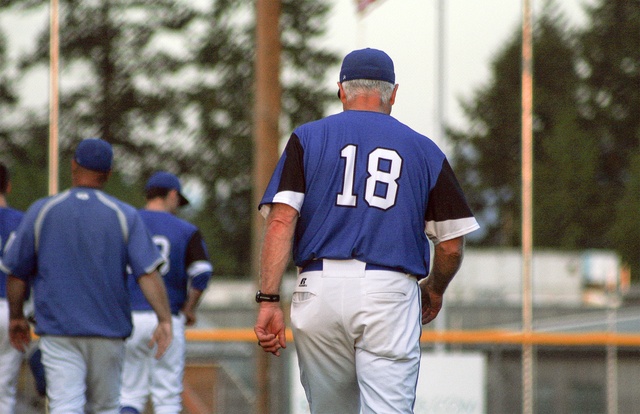 Bothell High baseball coach Paul Moody (18) walks toward his team after the Cougars’ 7-3 loss to Woodinville on Monday