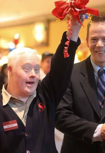 Longtime downtown Bothell Safeway employee Robert MacKay unleashes a celebratory yell after cutting the grand-opening ribbon with Bothell Mayor Mark Lamb at the city’s new store last Friday. Veteran Jeffery Sanchek also helped cut the ribbon.