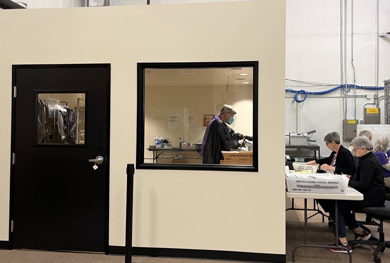 Election workers open mail in a new secure room at Thurston County’s elections office. The county invested in a separate room to open mail after it was sent an envelope containing fentanyl last year. (Laurel Demkovich/Washington State Standard)